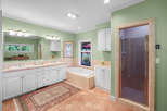 This spacious bathroom features a large vanity with dual sinks and ample storage, perfect for any household.
