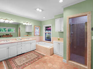 This spacious bathroom features a large vanity with dual sinks and ample storage, perfect for any household.