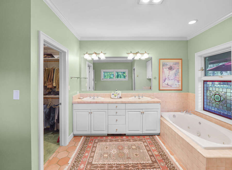 Indulge in this luxurious bathroom featuring a spacious jacuzzi tub perfect for relaxation.