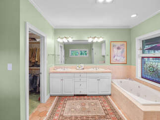 Indulge in this luxurious bathroom featuring a spacious jacuzzi tub perfect for relaxation.