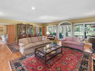 Step into this elegant living room, featuring a large sectional sofa and a plush pink sofa perfect for relaxation.