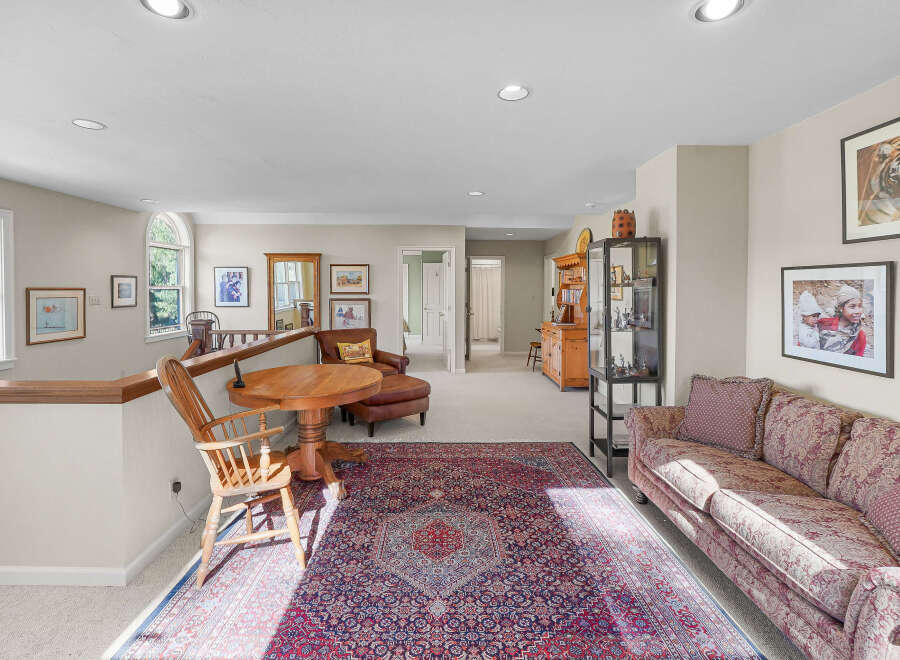 This spacious loft area offers a comfortable living space with a large oriental rug and a plush sofa, perfect for relaxation.