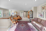 This spacious loft area offers a comfortable living space with a large oriental rug and a plush sofa, perfect for relaxation.