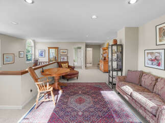 This spacious loft area offers a comfortable living space with a large oriental rug and a plush sofa, perfect for relaxation.