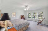 This charming bedroom features a comfortable bed with a floral comforter and a decorative bed skirt.