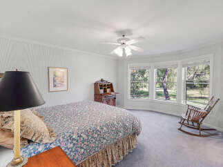 This charming bedroom features a comfortable bed with a floral comforter and a decorative bed skirt.
