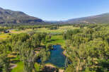 Discover this stunning property featuring a serene private pond surrounded by lush trees and expansive green fields.