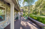 Enjoy the serene mountain setting from this expansive wooden deck, perfect for outdoor living.