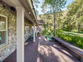 Enjoy the serene mountain setting from this expansive wooden deck, perfect for outdoor living.