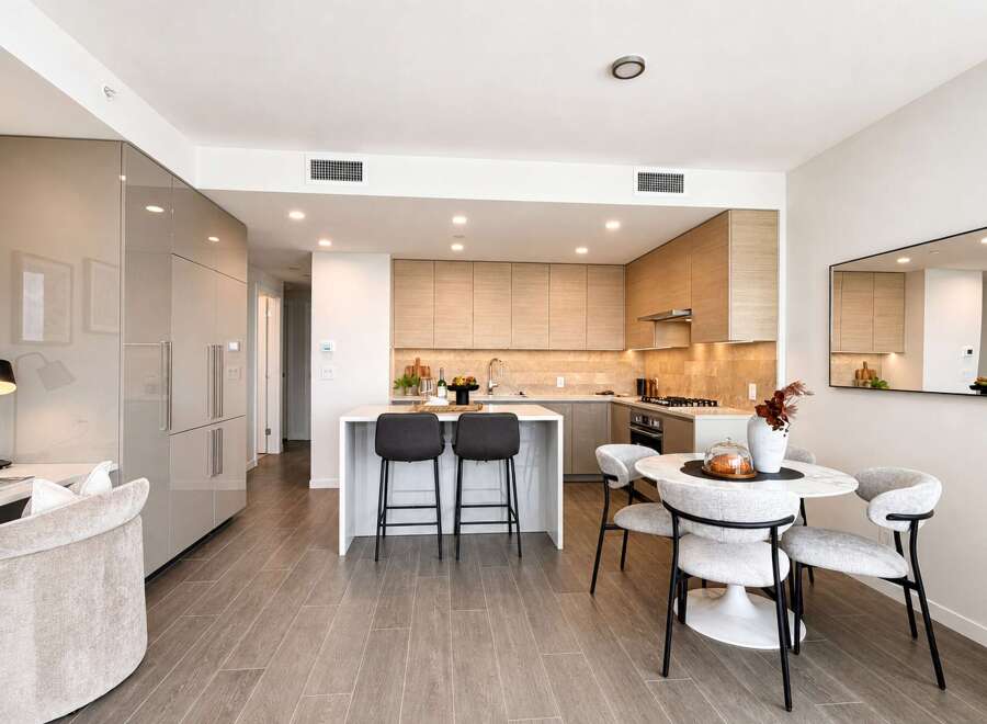 Experience modern living in this stunning open-concept condo, featuring a sleek, integrated kitchen with high-end appliances and ample cabinet space.
