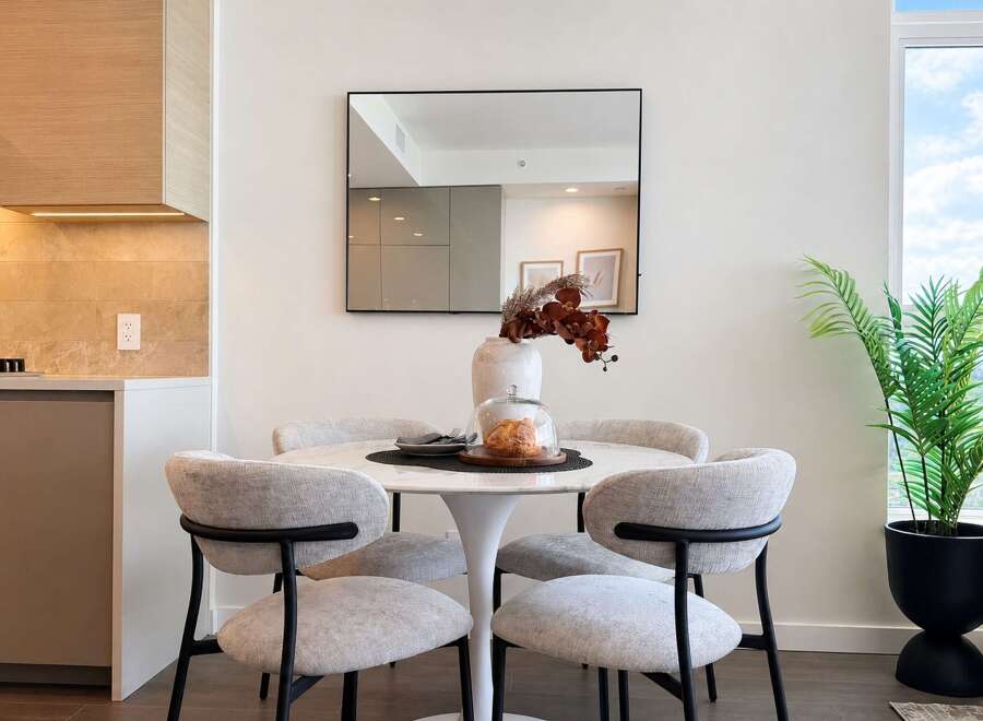 Experience modern living in this beautifully appointed dining area, featuring a sleek tulip-style table and comfortable upholstered chairs.