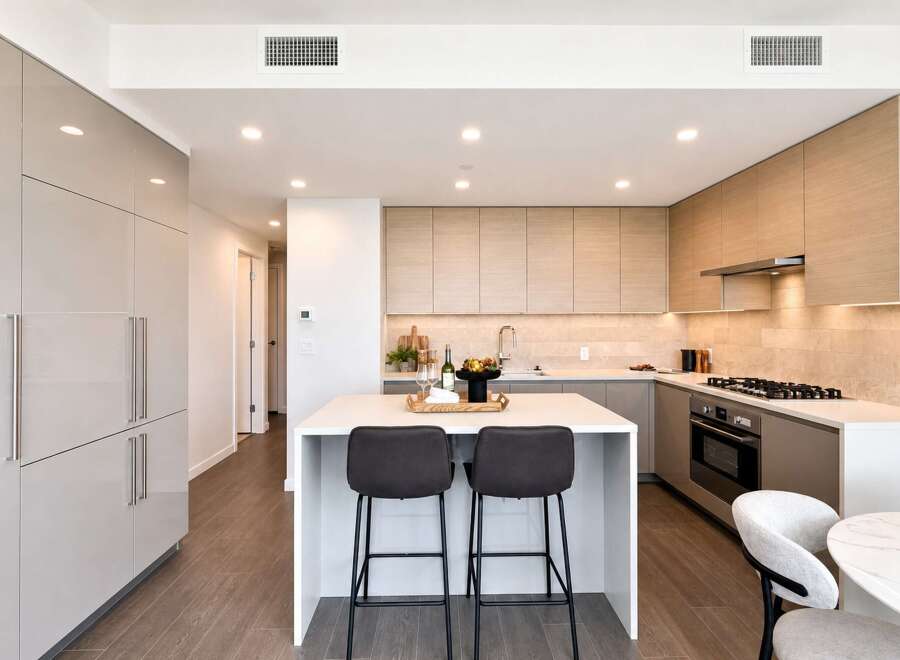 Experience modern luxury in this stunning kitchen featuring sleek, handleless cabinetry and a spacious island perfect for entertaining.