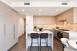Experience modern luxury in this stunning kitchen featuring sleek, handleless cabinetry and a spacious island perfect for entertaining.