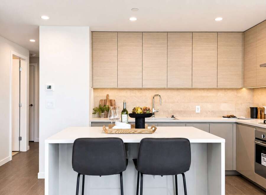 Experience modern living in this stunning kitchen featuring sleek, light wood cabinetry and a spacious white island perfect for entertaining.