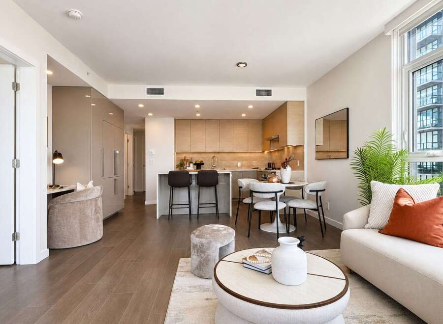 Experience modern living in this stunning open-concept condo, featuring a sleek kitchen with ample cabinetry and a breakfast bar perfect for casual dining.
