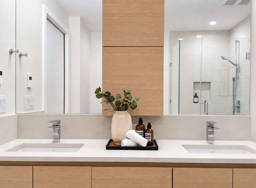 Experience modern luxury in this stunning bathroom featuring a dual vanity with sleek chrome faucets and integrated sinks.