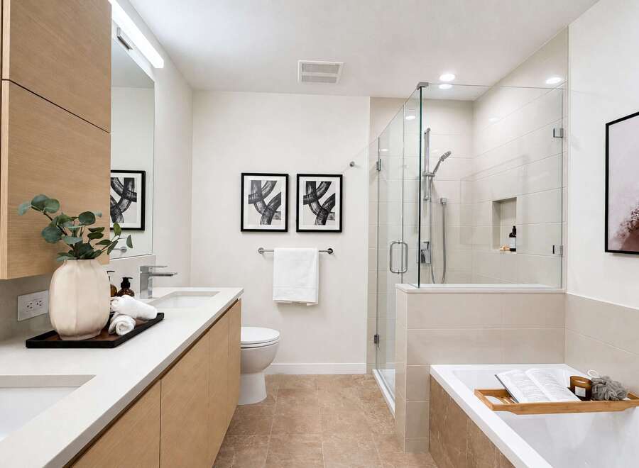 Experience modern luxury in this stunning bathroom, featuring a sleek vanity with ample storage and a spacious walk-in shower with a rainfall showerhead.