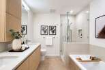 Experience modern luxury in this stunning bathroom, featuring a sleek vanity with ample storage and a spacious walk-in shower with a rainfall showerhead.