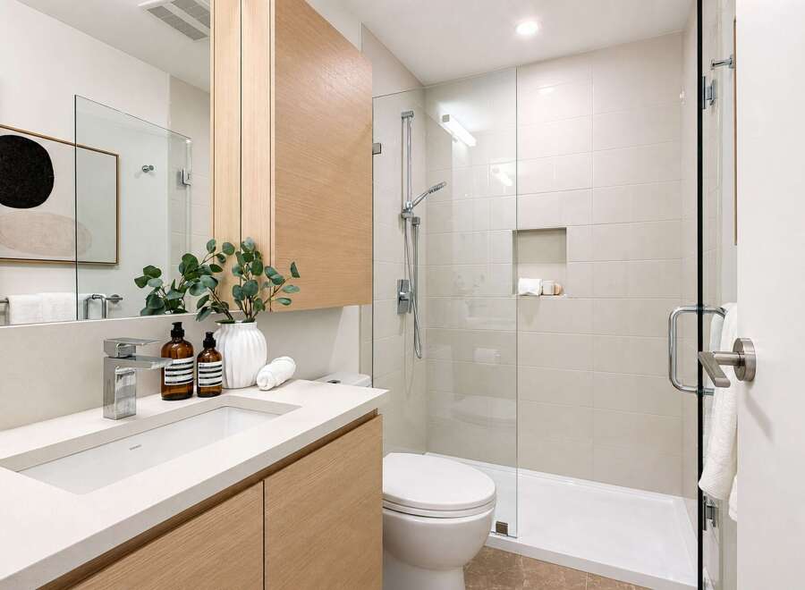 Experience modern luxury in this beautifully appointed bathroom, featuring a sleek vanity with ample storage and a minimalist aesthetic.