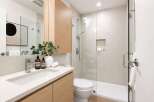 Experience modern luxury in this beautifully appointed bathroom, featuring a sleek vanity with ample storage and a minimalist aesthetic.
