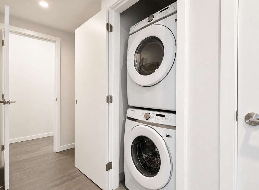 Discover modern convenience with this stacked Samsung washer and dryer set, perfectly integrated into a compact laundry closet.