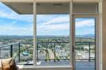 Experience breathtaking panoramic views from this stunning property, featuring expansive windows and a private balcony overlooking a vibrant cityscape.