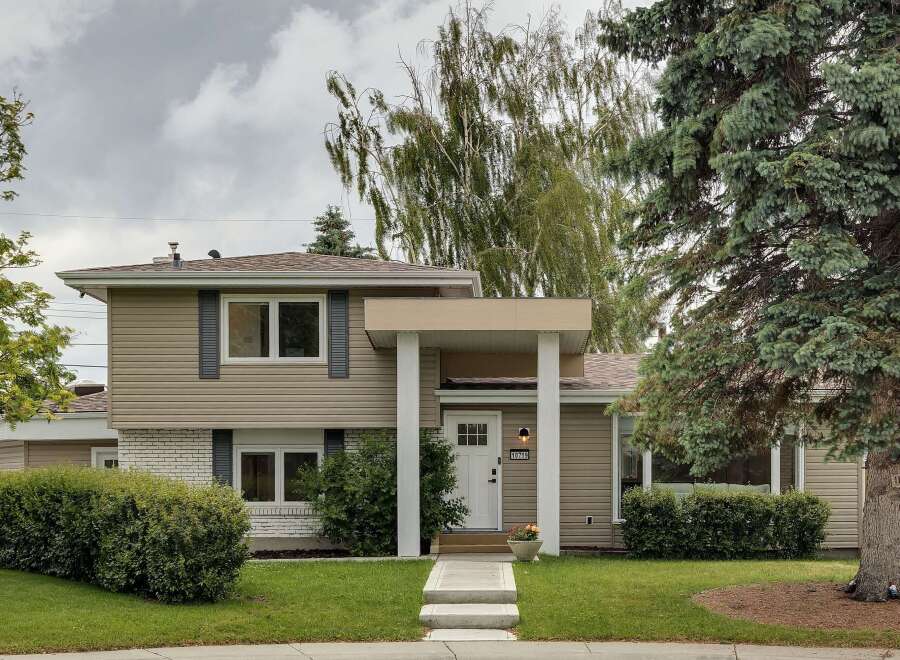 Charming two-story home featuring a welcoming covered porch with white columns and a bright white front door.