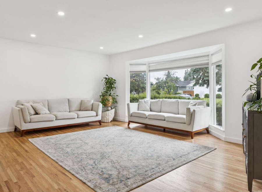 Step into this bright and airy living room, featuring a large bay window that floods the space with natural light.