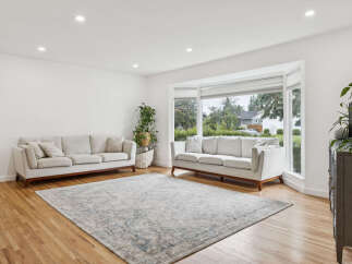 Step into this bright and airy living room, featuring a large bay window that floods the space with natural light.
