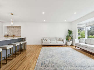 Experience modern living in this spacious open-concept home featuring a sleek kitchen island with bar seating and elegant pendant lighting.