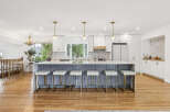 This stunning kitchen boasts a large island with grey cabinetry and white bar stools, perfect for casual dining and entertaining.