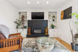 Cozy living room featuring a black brick fireplace with a mounted TV and built-in shelving.