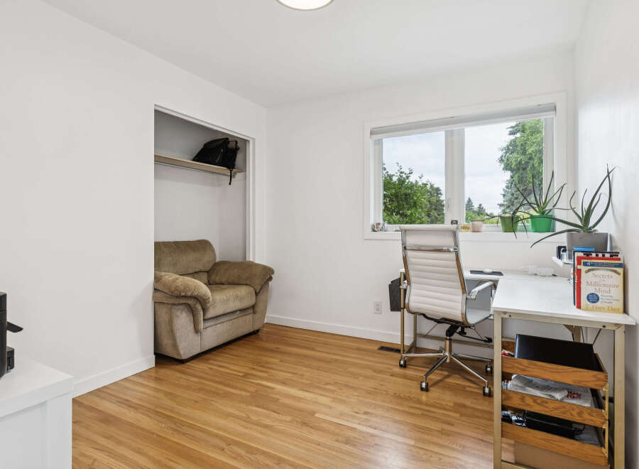 This bright and airy home office features a comfortable armchair in a built-in closet, perfect for reading or relaxing.