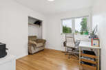 This bright and airy home office features a comfortable armchair in a built-in closet, perfect for reading or relaxing.