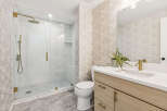 Experience luxury in this modern bathroom featuring a spacious glass-enclosed shower with marble tile and a rainfall showerhead.