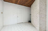 Discover this unique space featuring a rustic wooden ceiling and a charming white beadboard wall.