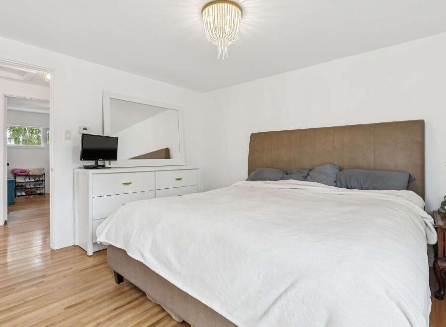 Experience comfort and style in this inviting bedroom, featuring a plush bed with a sophisticated headboard and a clean, modern dresser.