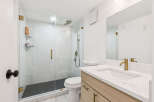 Experience modern luxury in this stunning bathroom featuring a spacious glass-enclosed shower with elegant marble tile and a sleek rainfall showerhead.