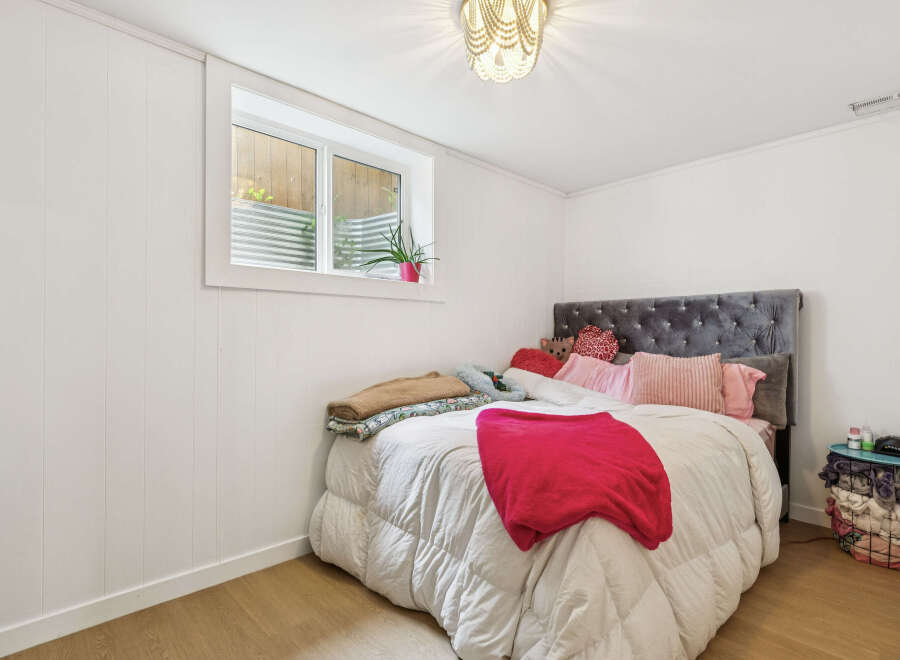 Discover this charming bedroom featuring a plush velvet headboard and a cozy comforter, perfect for relaxation.