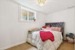 Discover this charming bedroom featuring a plush velvet headboard and a cozy comforter, perfect for relaxation.