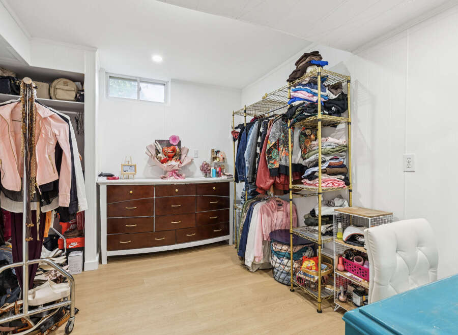 Discover organized living in this spacious room featuring a large dresser and ample shelving for all your storage needs.