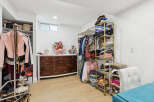 Discover organized living in this spacious room featuring a large dresser and ample shelving for all your storage needs.