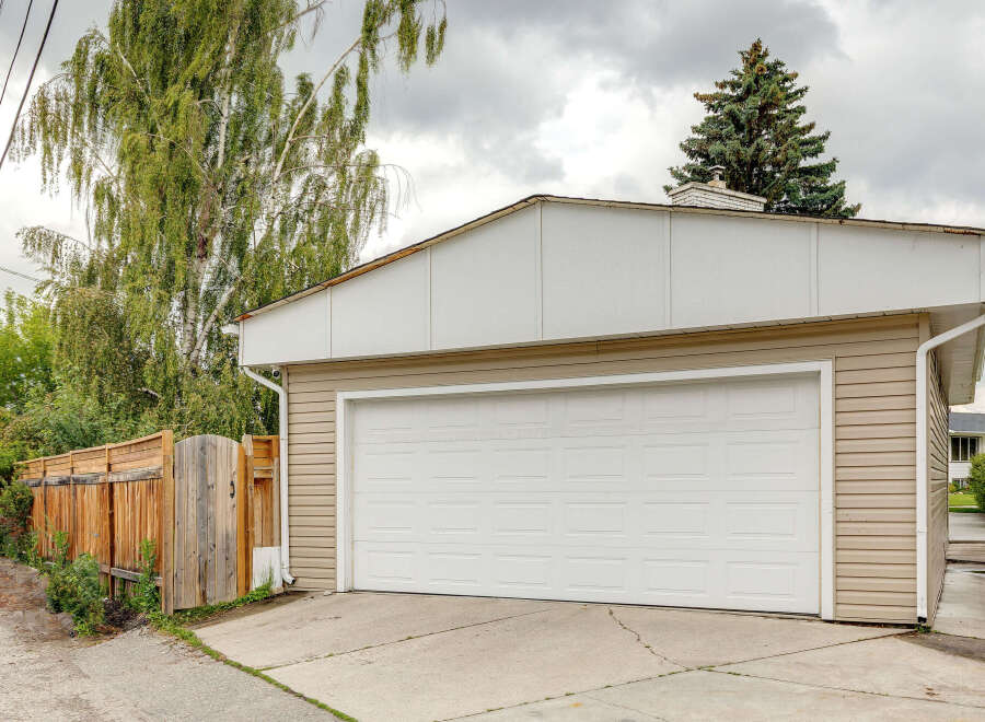 This property features a spacious two-car garage with a modern white overhead door, perfect for vehicle storage and workshop needs.