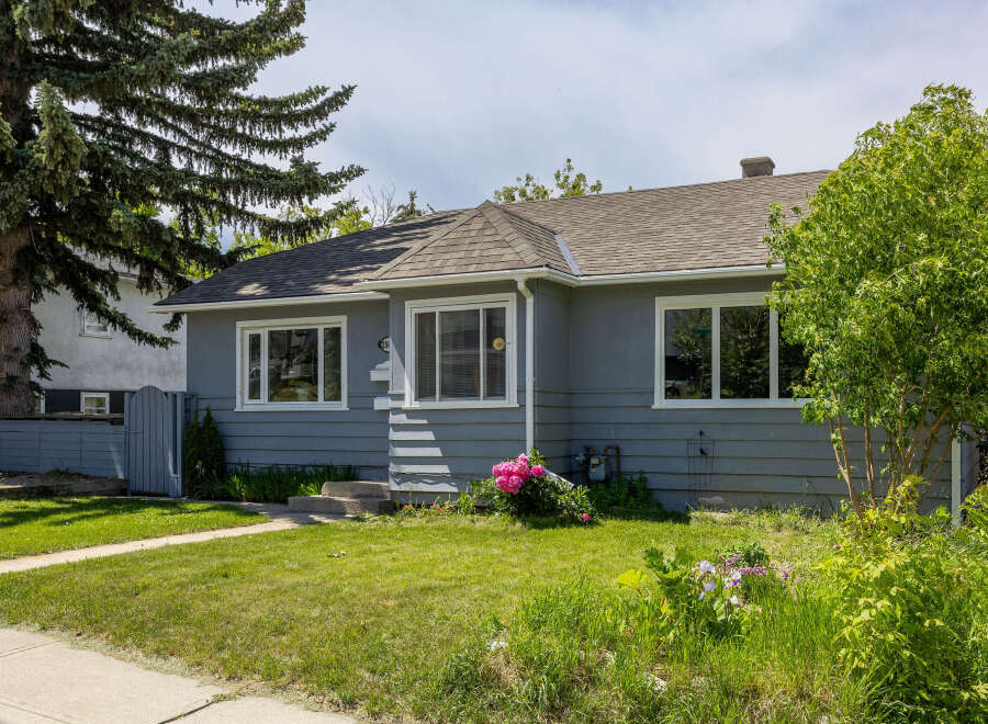 Charming single-family home featuring a welcoming gray exterior and a well-maintained lawn.