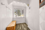 Welcome to this charming entryway, featuring a convenient wooden bench perfect for seating and storage.