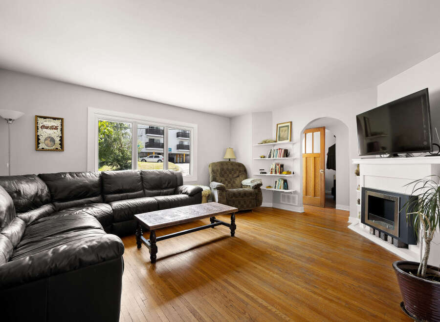 Step into this inviting living room, featuring a spacious black leather sectional sofa perfect for gatherings and a stylish coffee table.