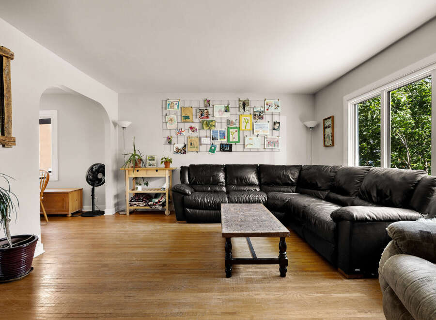 Step into this inviting living room, featuring a spacious black leather sectional sofa perfect for family gatherings.