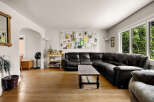 Step into this inviting living room, featuring a spacious black leather sectional sofa perfect for family gatherings.