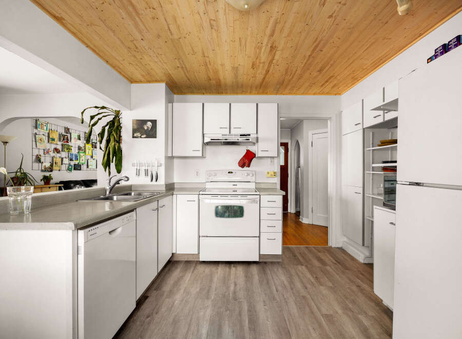 Discover this charming kitchen featuring white cabinetry and a sleek countertop, perfect for meal preparation.
