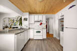 Discover this charming kitchen featuring white cabinetry and a sleek countertop, perfect for meal preparation.